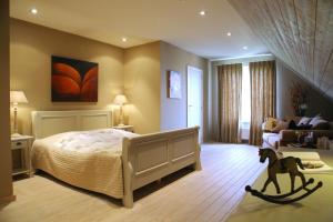 een slaapkamer met een bed met een paardenspeeltje op de voorgrond bij B&B Vallis Dyliae in Korbeek-Dijle