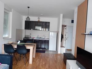 a kitchen and living room with a table and chairs at Suncokret in Kruševac