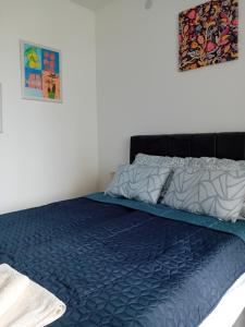 a bed with a blue comforter in a bedroom at Suncokret in Kruševac