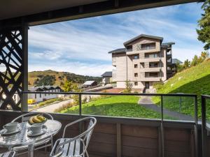a balcony with a table and chairs and a building at Confortable Appartement Familial aux Saisies avec Balcon et Parking - FR-1-809-6 in Les Saisies