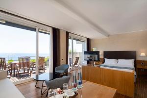 a hotel room with a bed and a balcony at Eurostars Monte Tauro in Taormina