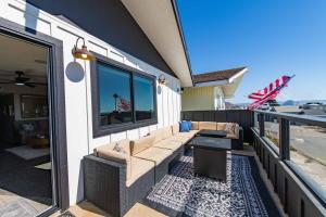 Un patio con un sofá y una mesa en un balcón. en Beach Bum Retreat, en Cayucos