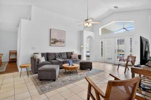 a living room with a couch and a table at Luxury 4-Bedroom Home with Private Pool, Jacuzzi, AC, Wi-Fi, Cable TV, 5 Minutes from Disney in Kissimmee