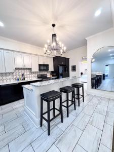 a kitchen with black and white counter tops and stools at Walking Distance to Downtown Free Parking in Tampa