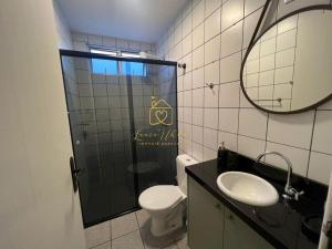 a bathroom with a toilet and a sink and a mirror at BETARA in Florianópolis +8 photos