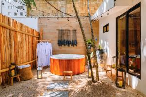 una vasca da bagno in una camera con parete in legno di Malish Hotel & Spa Luxury Edition a Playa del Carmen