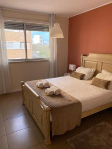 a bedroom with a large bed with towels on it at Exclusive Apartment in Quarteira Walk to Beach in Quarteira