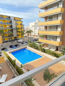 an apartment with a swimming pool in front of a building at Exclusive Apartment in Quarteira Walk to Beach in Quarteira