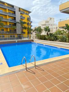 a swimming pool in front of a building at Exclusive Apartment in Quarteira Walk to Beach in Quarteira
