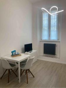 Ein weißes Zimmer mit einem Tisch und Stühlen sowie einem Computer. in der Unterkunft Casa Coralli in Pavia