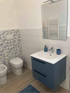 ein Badezimmer mit Toilette, Waschbecken und Spiegel in der Unterkunft Casa Coralli in Pavia