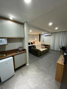 a kitchen and a living room with a couch and a kitchen and a living room at Manaus Hotéis Millenium - Flat 206 in Manaus