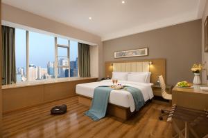 a hotel room with a bed and a large window at True Go Hotel - Guangzhou International Conference Center Memorial Hall Subway Station in Guangzhou +48 photos