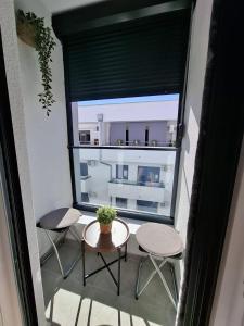 einen Balkon mit einem Tisch, 2 Stühlen und einem Fenster in der Unterkunft Apartman Dora in Jagodina
