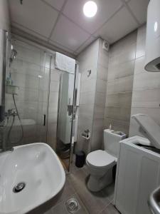 a bathroom with a sink and a toilet and a shower at Apartman Dora in Jagodina +12 photos