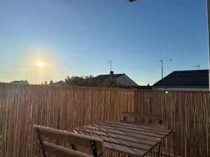 a wooden fence with a wooden table and a bench at chambre avec salle de bain, cuisine, balcon, clim et parking privé ,bordeaux centre Nansouty in Bordeaux