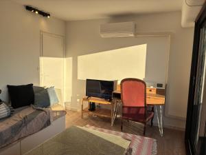 a room with a desk with a computer and a bed at chambre avec salle de bain, cuisine, balcon, clim et parking privé ,bordeaux centre Nansouty in Bordeaux