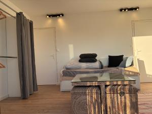 a room with two beds and a table in it at chambre avec salle de bain, cuisine, balcon, clim et parking privé ,bordeaux centre Nansouty in Bordeaux