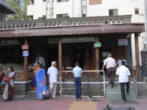 a group of people standing outside of a restaurant at SAIRATNA HOTEL only 1 minute distance from sai temple in Shirdi +9 photos