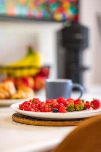 a plate of fruit on a counter with a cup at Stylish flat in the heart of Hitchin with free parking in Hitchin