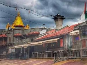 a group of buildings on a street with a cloudy sky at SAIRATNA HOTEL only 1 minute distance from sai temple in Shirdi