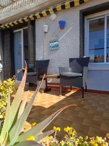 a patio with chairs and a table on a house at Sunny Beach Apartment - Big Terrace - Free WiFi in Calafell