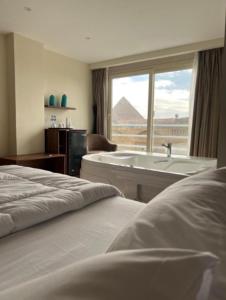 Habitación de hotel con 2 camas y bañera en pyramids palace view, en El Cairo