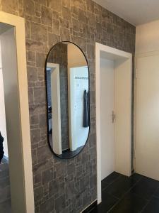 a bathroom with a stone wall and a mirror at Sehr gute Lage mit Straßenbahn vor der Tür & riesen Bett, Messe nah in Essen