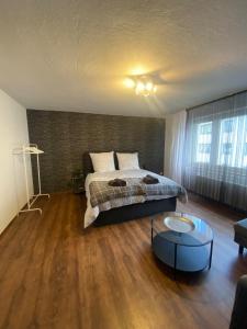 a bedroom with a bed and a coffee table at Sehr gute Lage mit Straßenbahn vor der Tür & riesen Bett, Messe nah in Essen