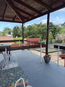 a patio with a table and chairs on a roof at Hostería Las Gemelas in Capilla del Monte