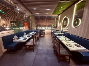 a dining room with long tables and blue booths at HOTEL VARISHTTA - Koparkhairane - Navi Mumbai in Navi Mumbai