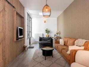 a living room with a couch and a tv at Huis Hendrik Geeraert in Nieuwpoort