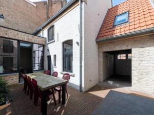 a patio with a table and chairs and a building at Huis Hendrik Geeraert in Nieuwpoort