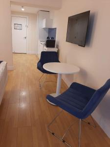 a room with a table and two chairs and a tv at Orbi siti in Batumi