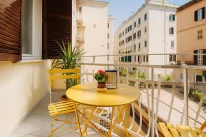 a small yellow table on a balcony with chairs at Vatican - Casa Cesarina in Rome