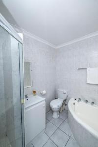Un baño con inodoro, bañera y lavabo. en Prime Executive Apartments 2, en Durbanville