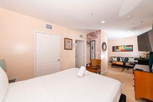 a bedroom with a white bed and a living room at South Of Fifth Studio With Pool in Miami Beach