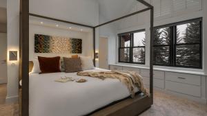 a bedroom with a large white bed with windows at Chalet Bello in Beaver Creek +27 photos