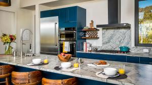 a kitchen with blue cabinets and a counter with two plates of food at Chalet Cascada in Steamboat Springs