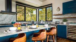 a kitchen with blue cabinets and a large counter with chairs at Chalet Cascada in Steamboat Springs