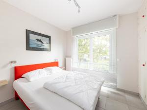 Un dormitorio blanco con una cama y una ventana. en Elisa Beta, en Nieuwpoort-Bad