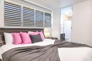 a bedroom with a large bed with pink pillows at AQUA Ville Moderna 1 - Spacious 4BR Villa-Suite with King Beds in Dorado