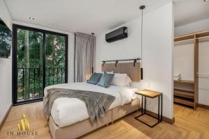 une chambre avec un lit et une grande fenêtre dans l'établissement Morph 201 - High ceilings & modern apt/BBQ, à El Poblado 40 autres photos
