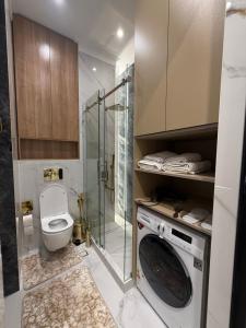 Un baño con inodoro y lavadora. en Sky Nest Apartments, en Tashkent 57 fotos más