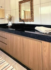 een badkamer met een zwarte wastafel en een spiegel bij Casa Mirante 360 in Cavalcante