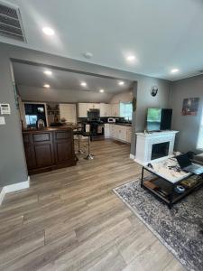a large living room with wooden floors and a kitchen at Walk to Downtown | Workspace + Pet Friendly in Pleasanton