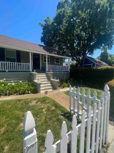 a white picket fence in front of a house at Walk to Downtown | Workspace + Pet Friendly in Pleasanton