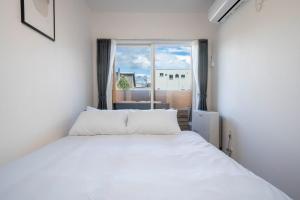 a white bed in a room with a window at MKS202 - Vacation STAY 20135 in Gojōdōri