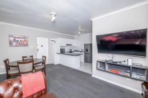 Una sala de estar con televisión y un comedor. en Prime Executive Apartments 2, en Durbanville 8 fotos más