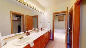 a bathroom with two sinks and a large mirror at Chalet Fairway in Beaver Creek